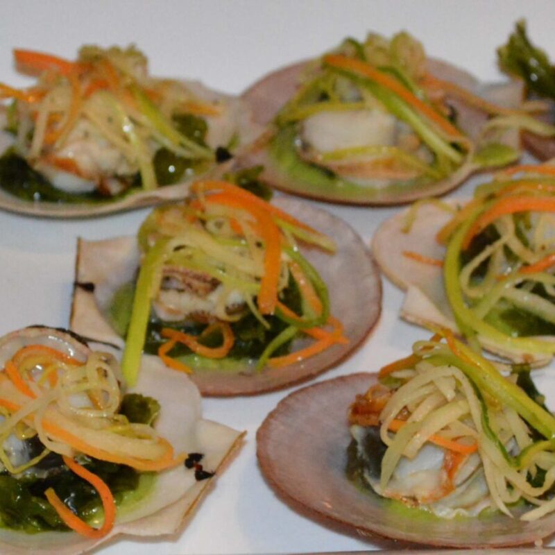 Coquille de pétoncle utilisé en assiette garnie de pétoncle aux algues avec un coulis d'asperges et des légumes tranchés finement.