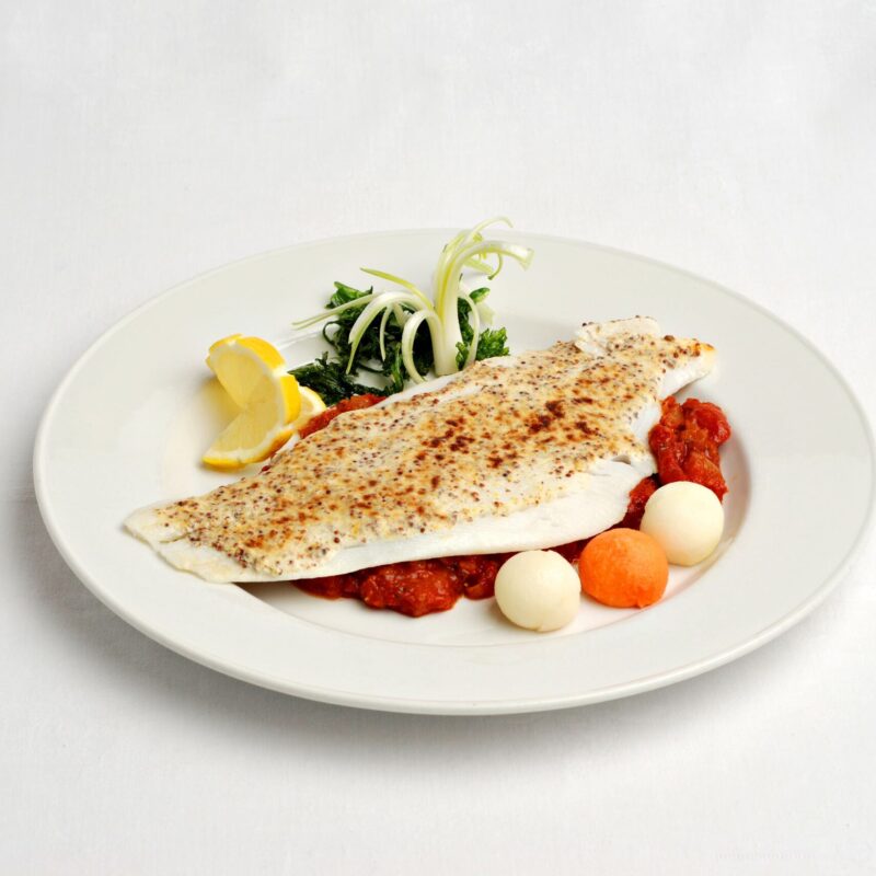 Filet de flétan du Groenland à la graine de moutarde et à la tomate accompagné de petits légumes.
