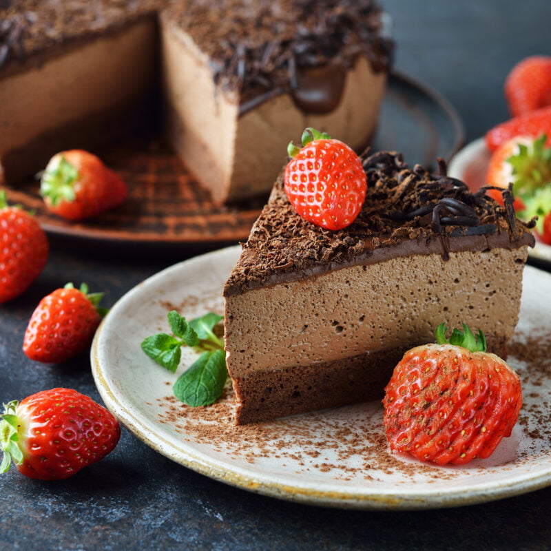 Photographie d'une part de gâteau au chocolat décoré de fraises.
