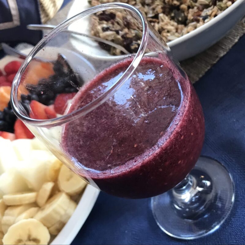 Verre avec dedans un smoothie aux fruits rouges et à la spiruline marine.