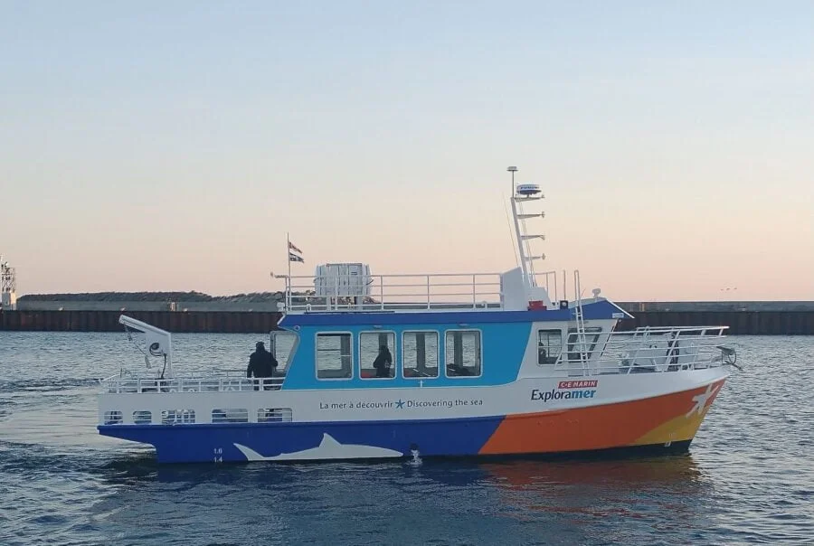 Exploramer boat on the water, side view.