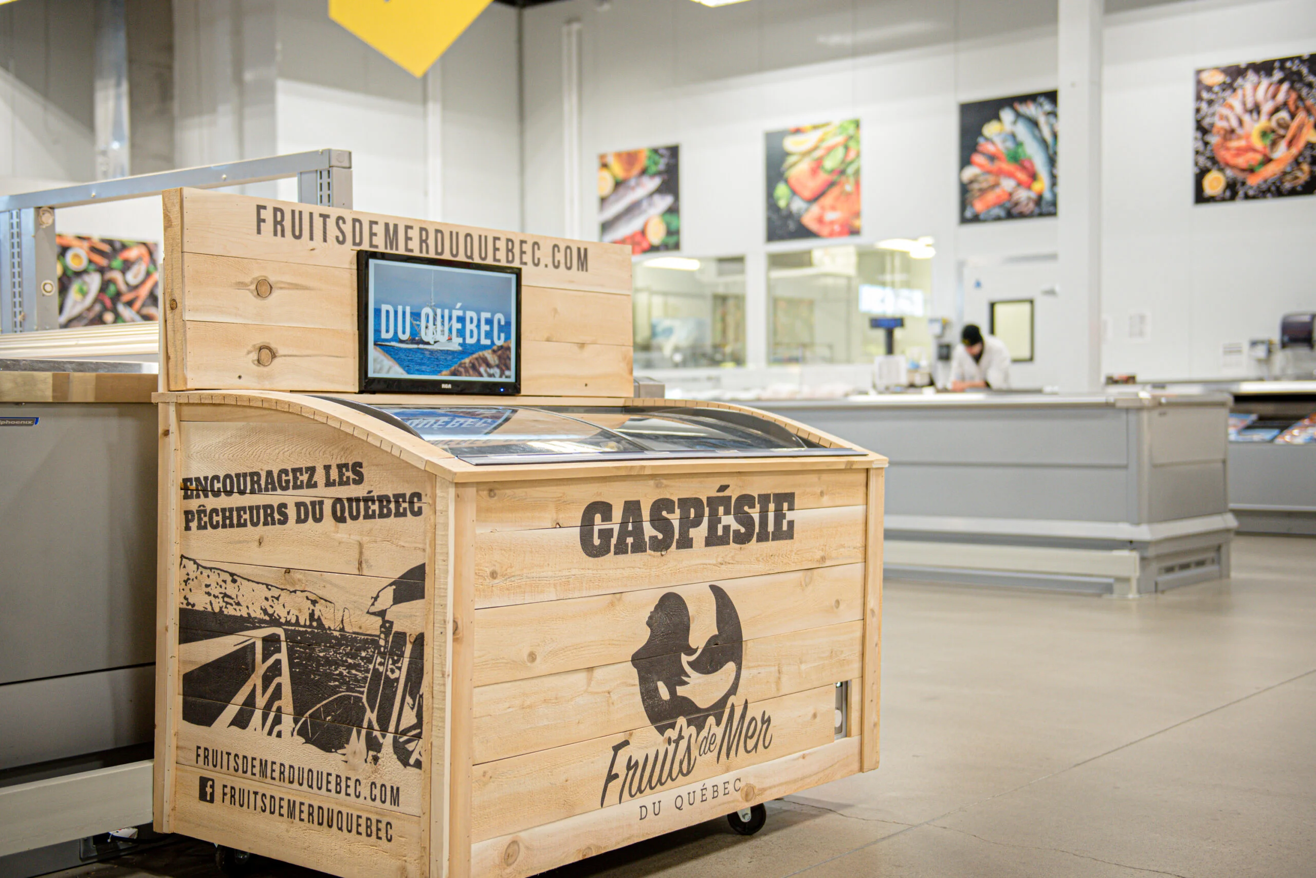 Photograph of a wooden stall in a fishmonger's shop with “Gaspésie” and “Fruits de mer du Québec” written on it.
